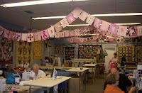 Inside of the shop showing several clothesline rows with pink banners hanging from them