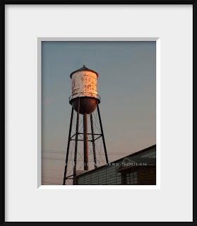 Old water tower with sunset glow in frame.
