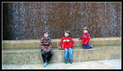 three boys in front of one of the many fountains in Thanksgiving Square