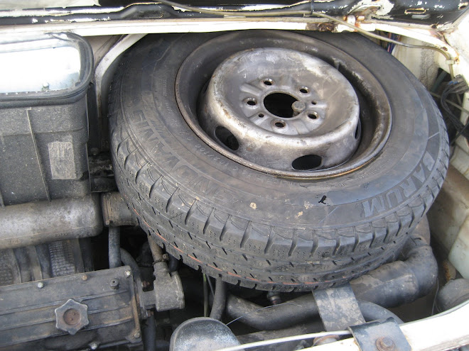 Engine bay (driver's side). Shows spare tire.