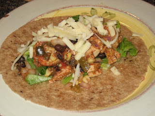 plate with the wrap not rolled up with chicken, black beans, jalapeno, corn, red onions, lettuce, and cheese
