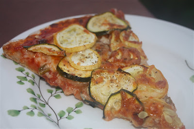 pizza slice on a plate topped with zucchini and squash