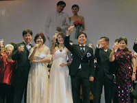The wedding couple and their parents toasting on stage with their guest
