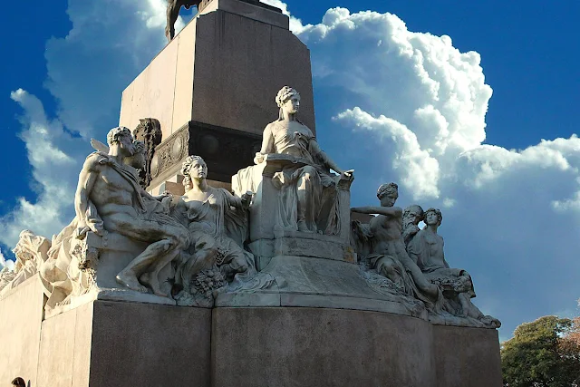 Figuras escultóricas en la base del monumento a Mitre.