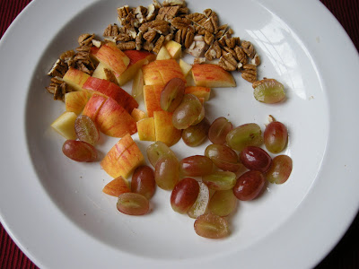 Coarsely chop pecans, apple, and grapes.