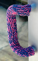 door handle with purple and pink tweed knitted sleeve on it