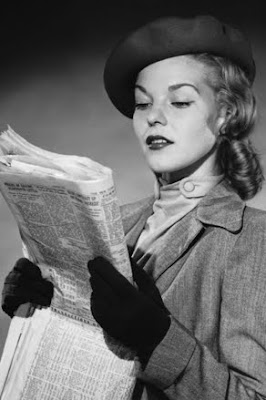 black and white photo of woman reading want adds dressed for job search, circa 1930s
