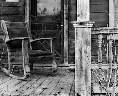 black and white photo of rocking chair on old porch