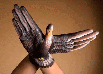 hands painted with feathers and forming shadow bird