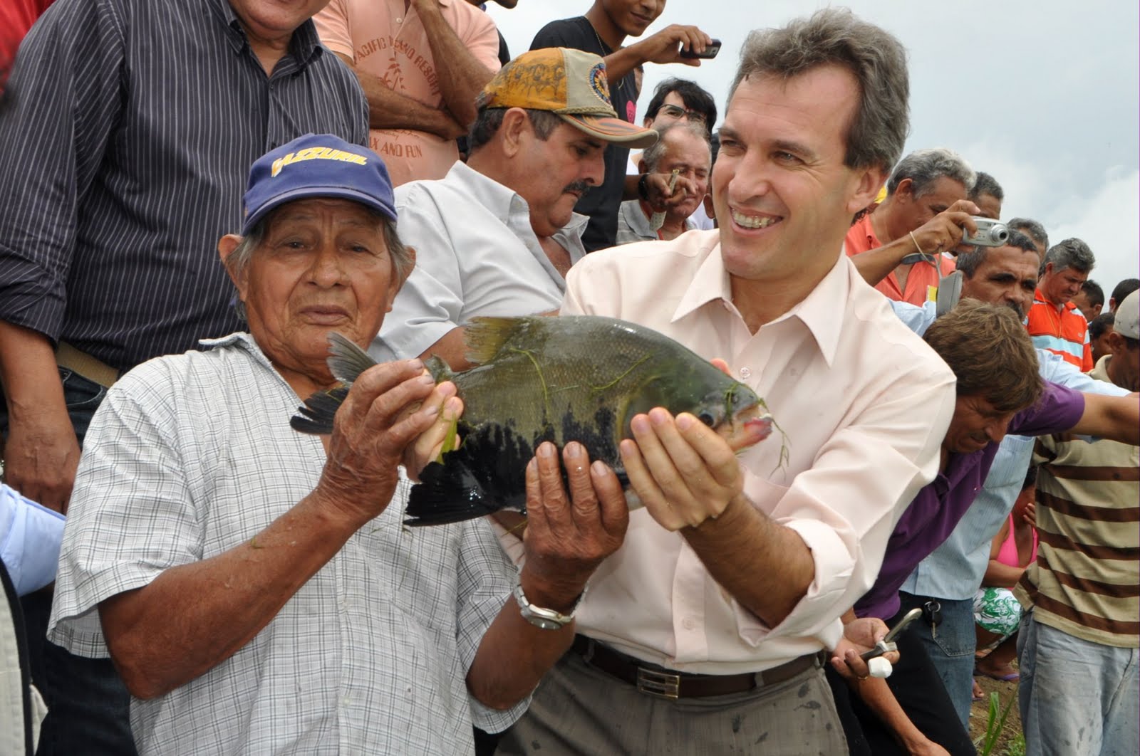 O piscicultor Zé Moura segurando um exemplar de sua produção, ladeado pelo Ministro da Pesca e Aquicultura, Altemir Gregolin