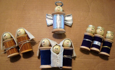 Thread spools made to look like a full nativity scene. From left to right, (left) two shepherds, (middle top) angel, (middle bottom) Jesus; Mary; and Joseph, (right) three wise men. 