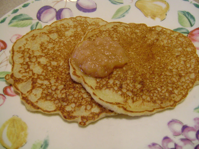 Two Applesauce Pancakes on a plate with applesauce topping
