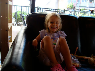 Young girl crouched up on couch smiling