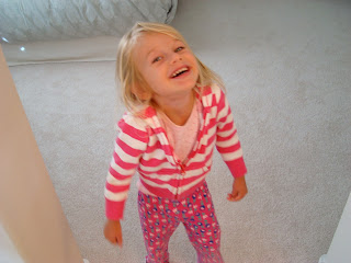 Young girl in doorway wearing pink and smiling