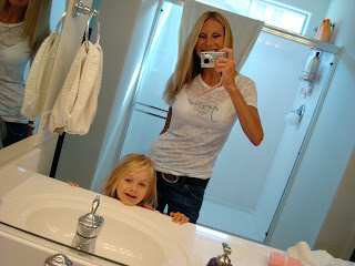 Woman and child taking picture together in mirror