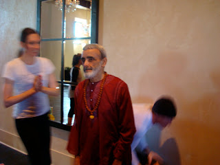 Dharma Mittra standing with two people in front of wall