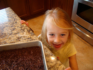 Little girl next to fudge on countertop with tongue out