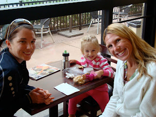 Two women and child sitting at table in coffee shop