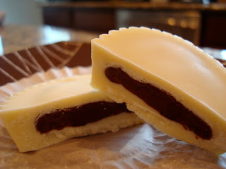Vegan White Chocolate Chocolate-Peanut Butter Cup split in half on paper liner