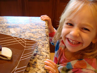Young girl smiling in front of plate of peanut butter cups