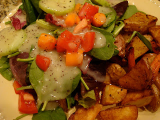 Mixed greens and vegetable salad with dressing served with roasted vegetables