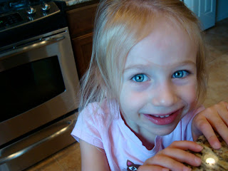 Young girl in kitchen holding onto countertop