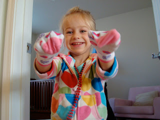 Young girl wearing socks on hands smiling