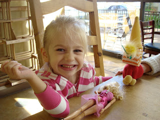 Young girl smiling at table playing with toys