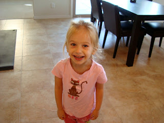 Young girl in pink shirt standing in kitchen