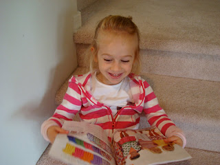 Young girl sitting on steps looking at catalog