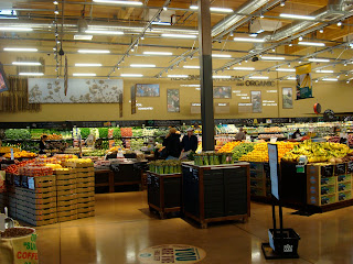 Inside grocery store showing stacked produce