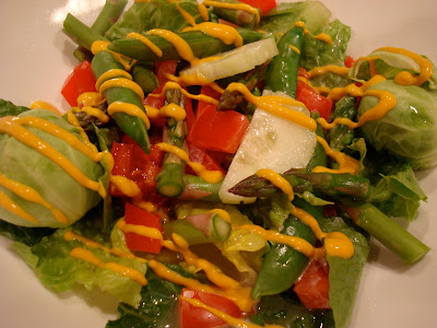 Green salad with mixed vegetables drizzled with mustard