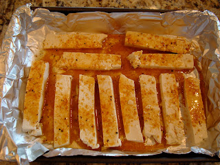 Sesame Ginger Maple sauce poured over sliced tofu in foil lined pan