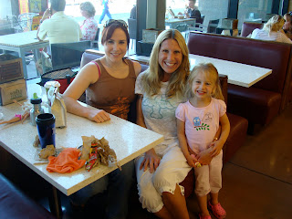Two women and young girl sitting in booth smiling