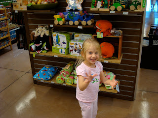 Young girl standing in front of toys in store