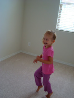 Little girl in pink and purple dancing in room