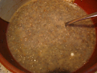 Water, almond milk and chia seeds in bowl being mixed with spoon