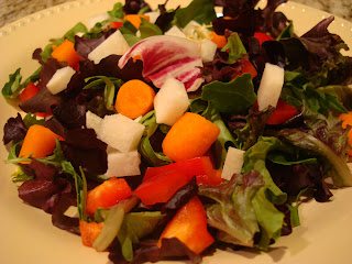 Raw vegetables tossed together in round white shallow bowl