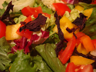 Close up of Dulse Flakes over a vegetable and greens salad
