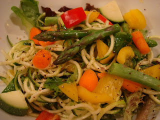 Spiralized zucchini noodles with mixed vegetables topped with dressing