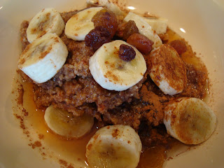 Raw Vegan Apple Carrot (Pan)Cakes on plate topped with sliced bananas, maple syrup, raisins and cinnamon 