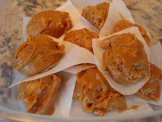 Stacked Raw Vegan Peanut Butter Cookie Dough Balls in container separated by parchment paper