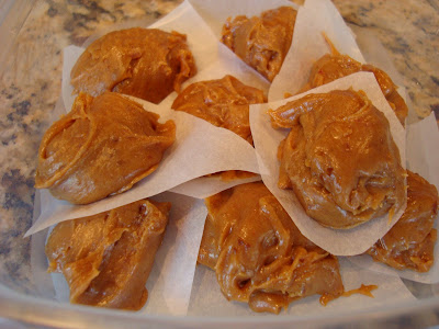 Raw Vegan Peanut Butter Cookie Dough Balls stacked in clear container with parchment paper