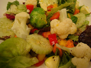 Close up of mixed green and vegetable salad in white bowl