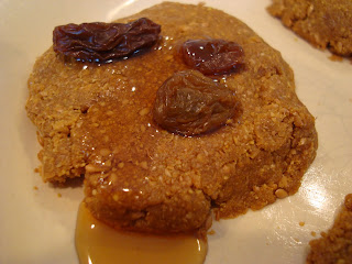 Up close of Vegan Maple & Flax "Peanut Butter" Pancake-Cookies on plate topped with raisins and maple syrup