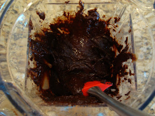 Spatula scraping sides of blender with mixture inside