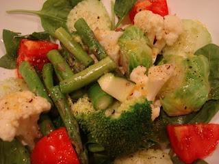 Spinach topped with mixed vegetables in dressing