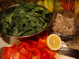 Sliced red pepper, kale, lemon and cashews on countertop