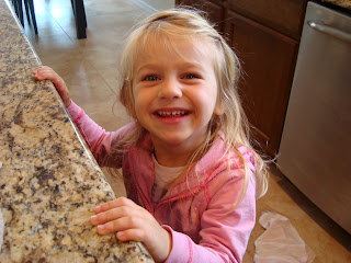 Little girl smiling with hands on countertop