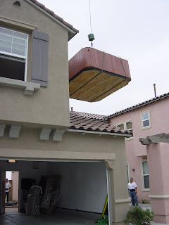 Hot Tub being lowered down to ground by crane